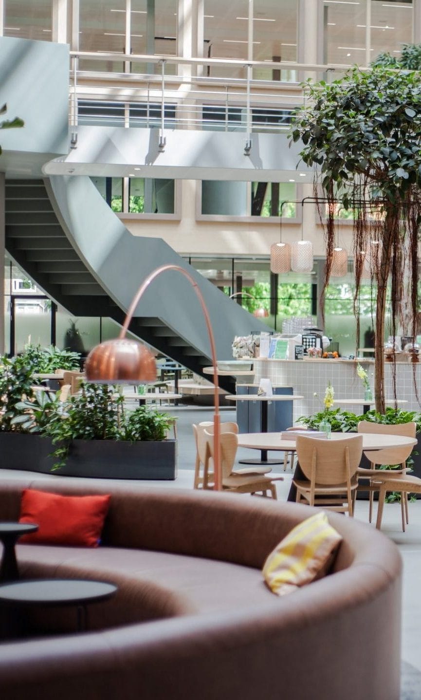 Das Atrium von Stadium mit seinen Pflanzen und bequemen Sitzgelegenheiten, ohne dabei die professionelle Atmosphäre und das biophile Design aufzugeben