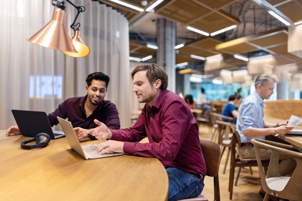 Employees collaborating in a modern office environment, highlighting how AI-driven tools enhance productivity and improve the employee experience.